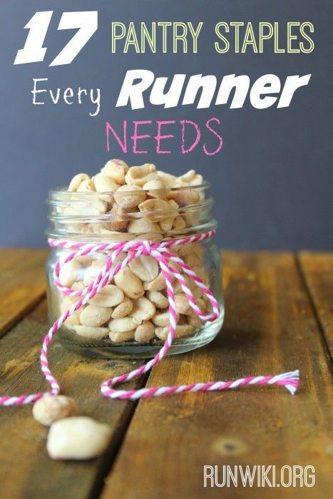 a mason jar filled with peanuts and pink twine on top of a wooden table