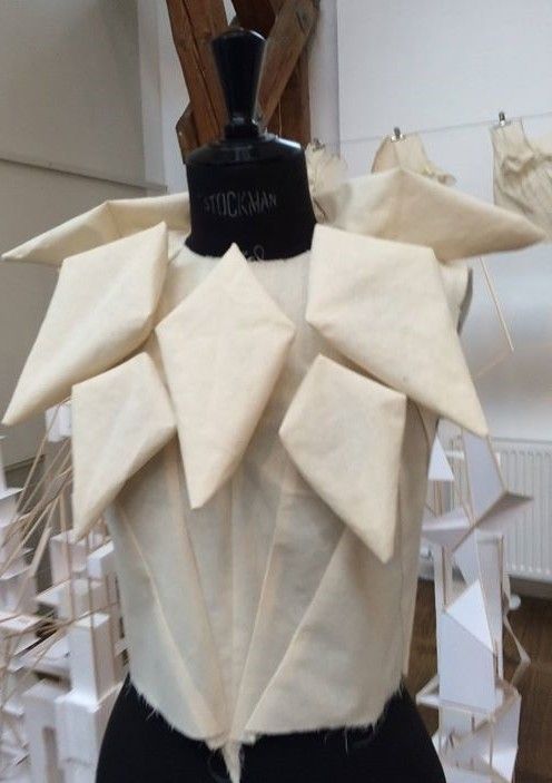 a mannequin wearing a white top with large bows on it's back