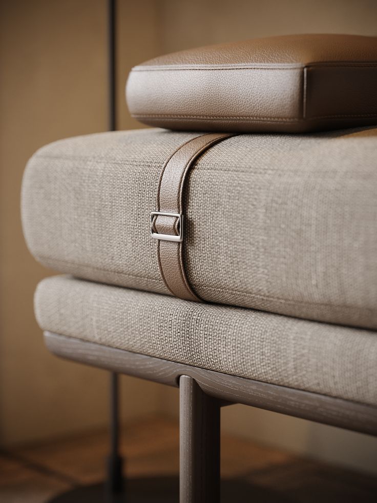 a pair of pillows sitting on top of each other next to a metal stand with a cushion