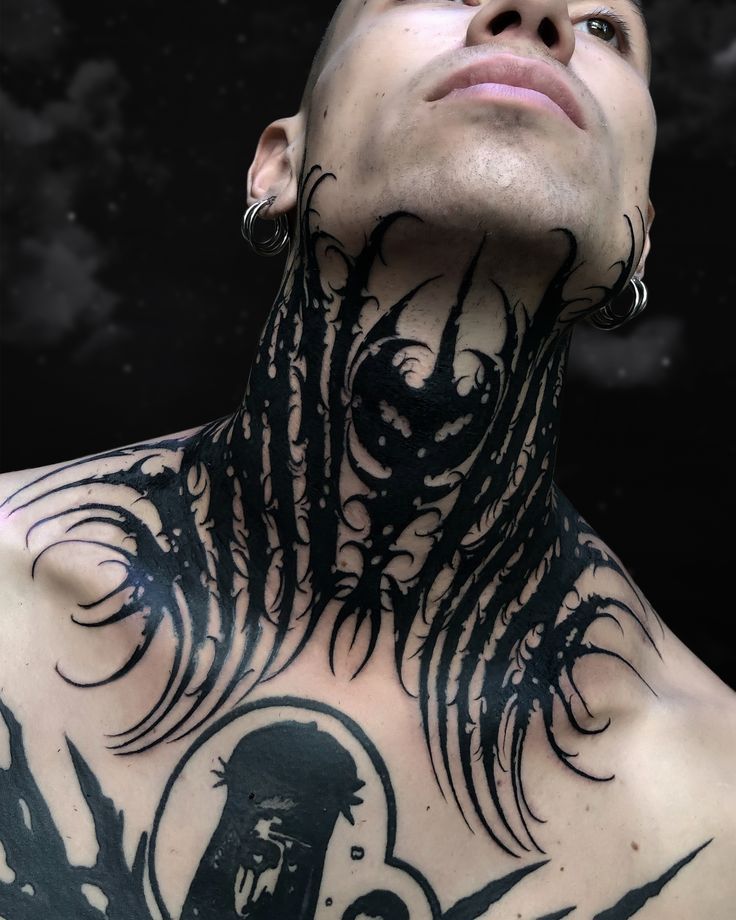 a man with tattoos on his neck and chest