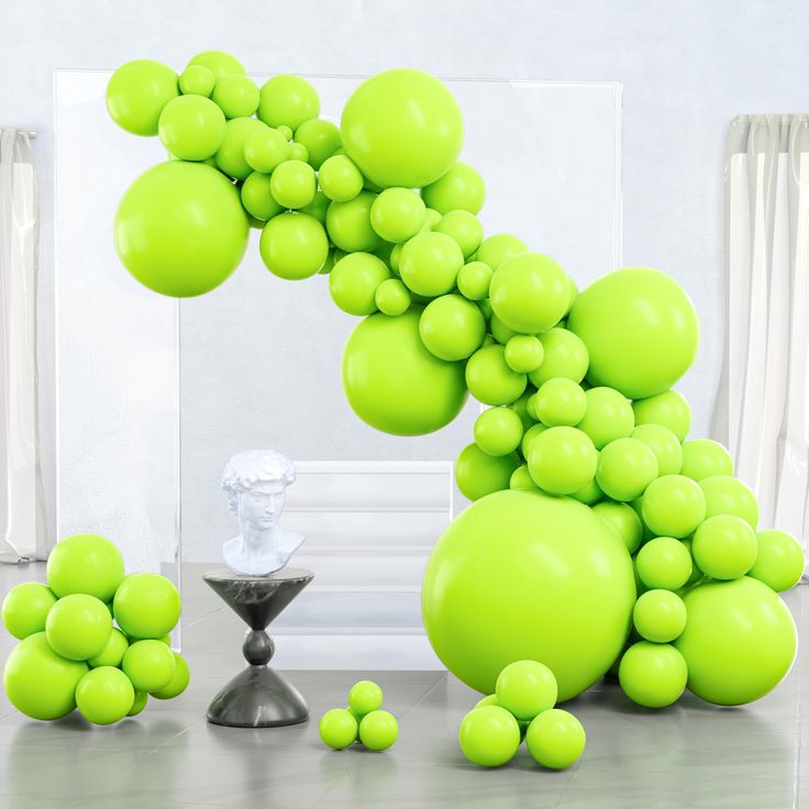 green balloons are floating in the air next to a sculpture