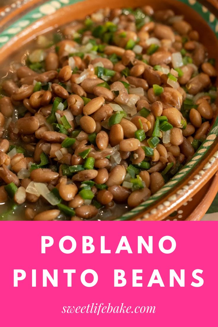 a bowl filled with beans and green onions on top of a wooden table next to a pink