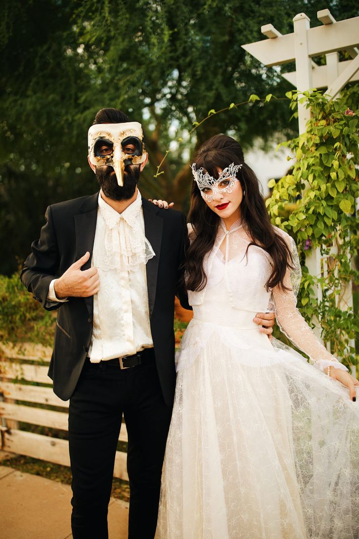 a man and woman dressed up in masks pose for a photo on their wedding day