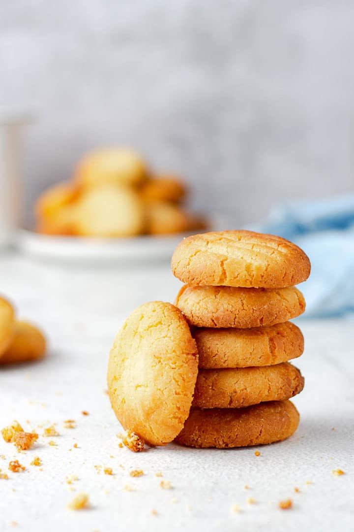 a stack of cookies sitting on top of a white table next to plates of cookies