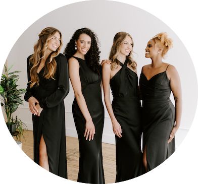 four beautiful women in black dresses standing together