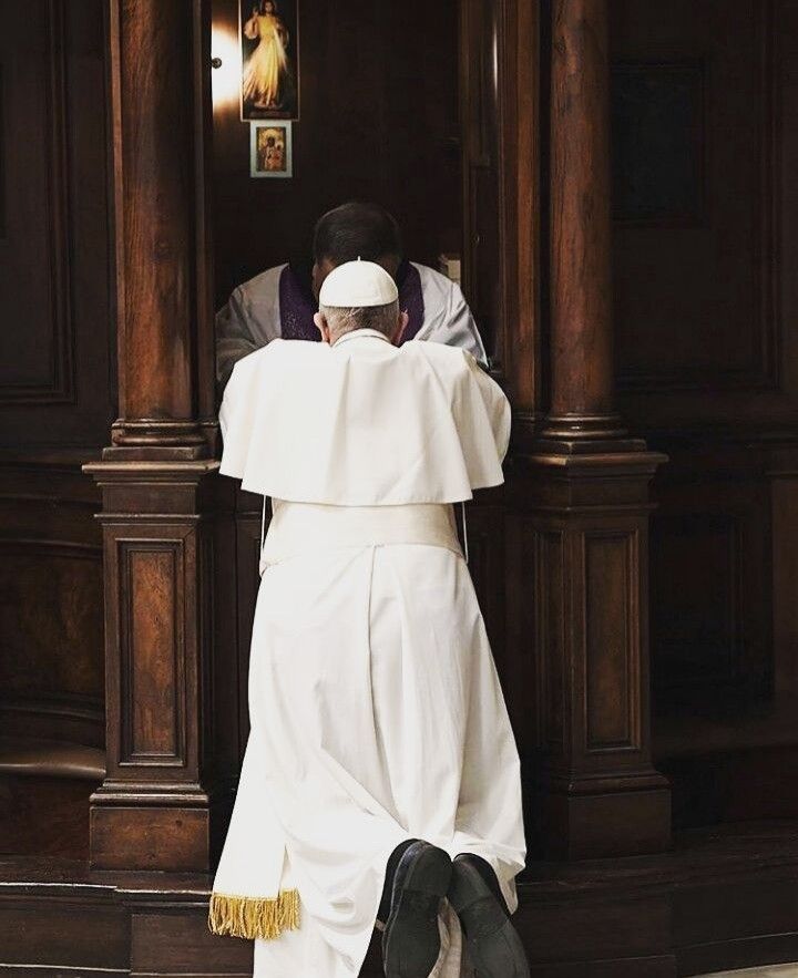 a man leaning against a wall with his hands on the back of his head, wearing a priest's outfit