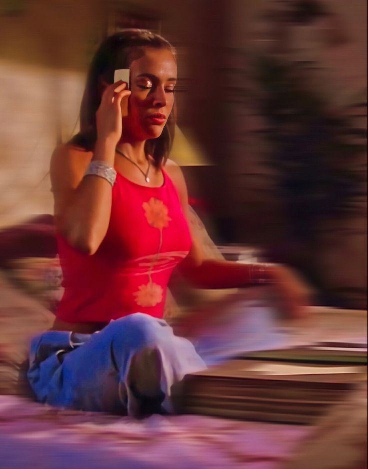 a woman sitting on the ground talking on her cell phone