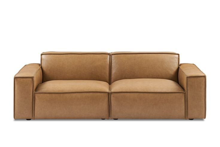 a brown leather couch sitting on top of a white floor