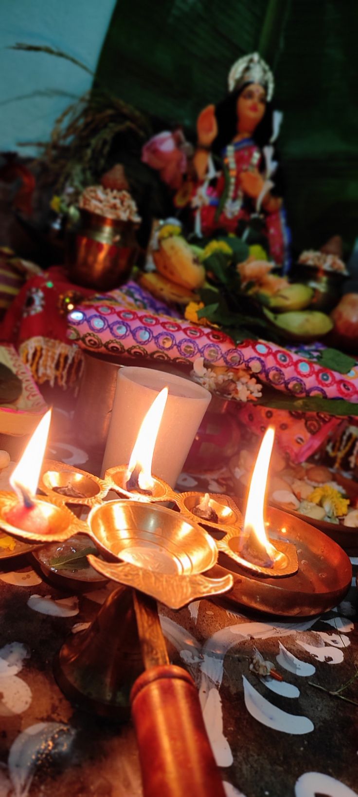 several lit candles on a table with other items in the background