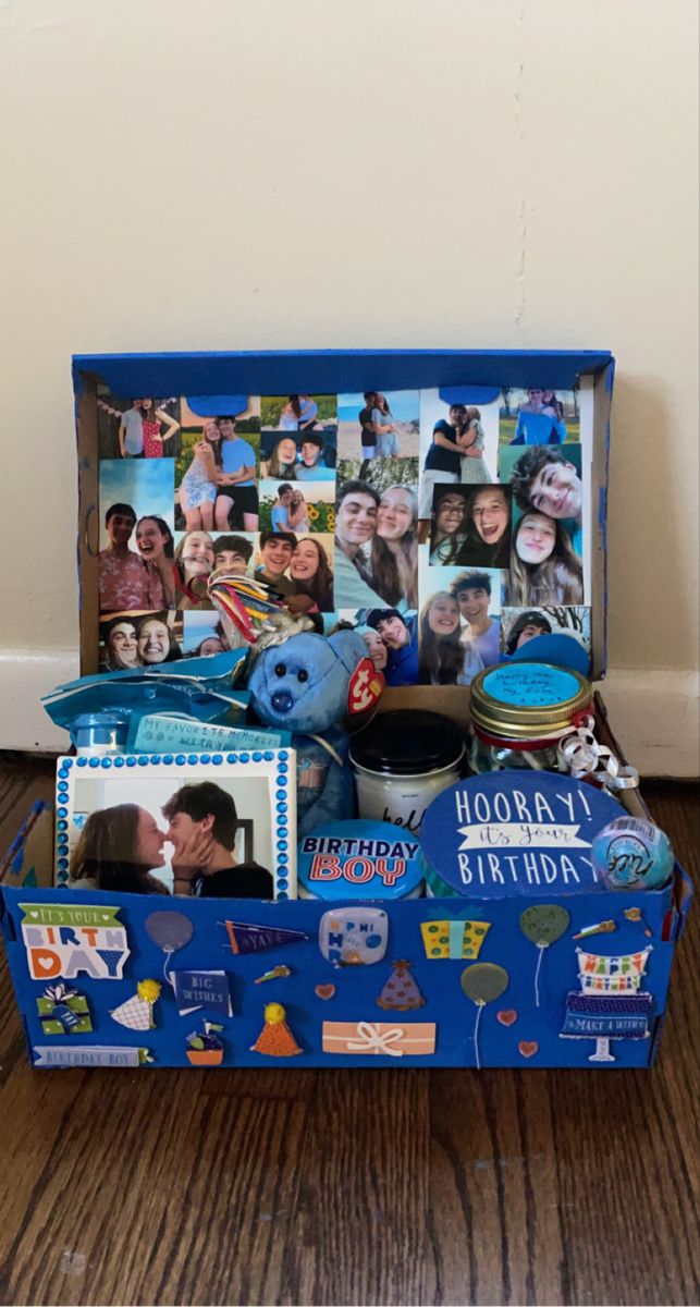 an open suitcase with pictures on it and other items in the bottom compartment, sitting on a wooden floor