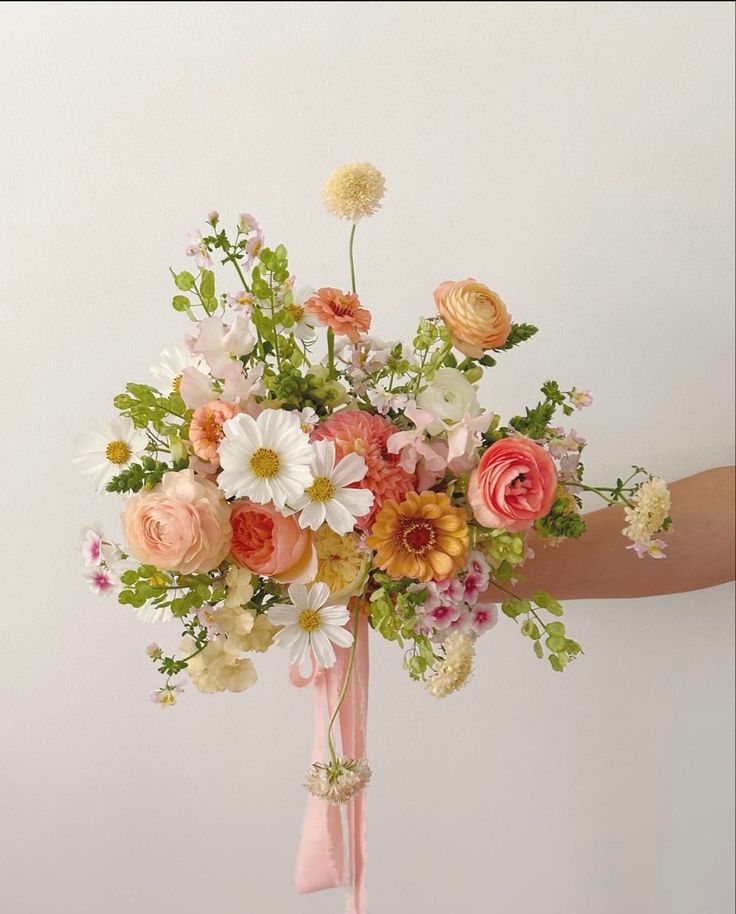 a person holding a bouquet of flowers in their hand