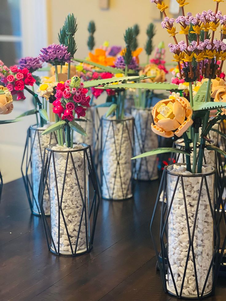 several vases with flowers in them sitting on a table