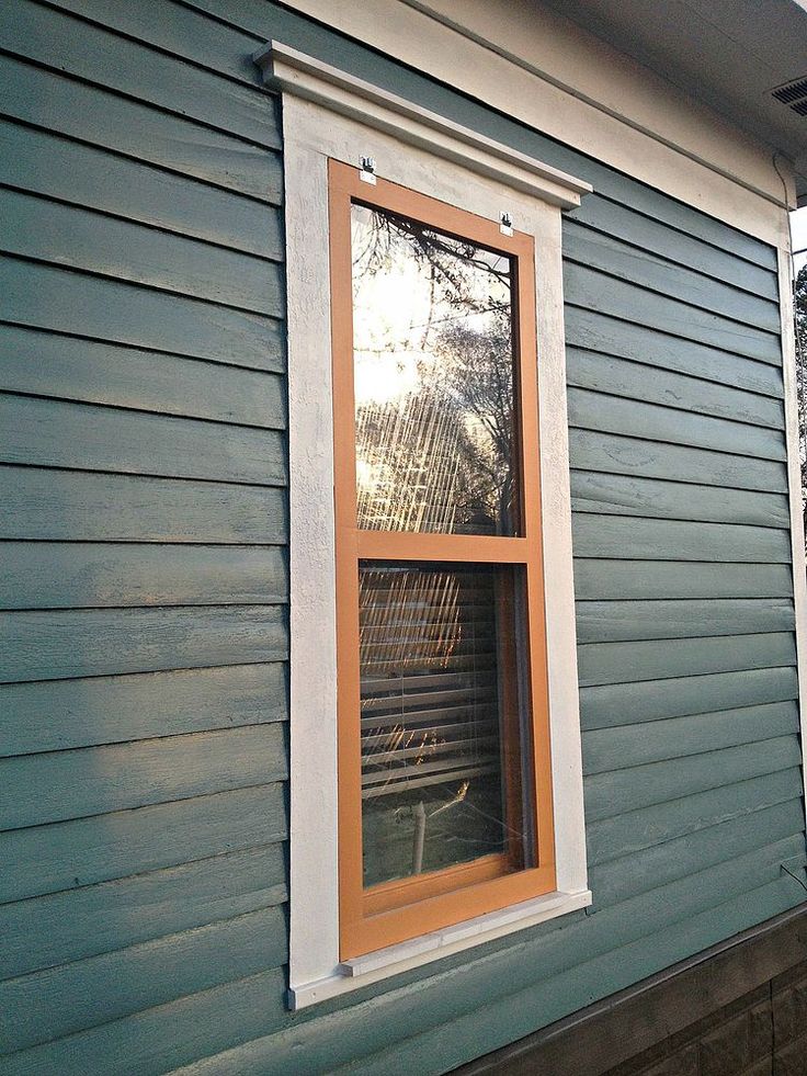 a window on the side of a blue house