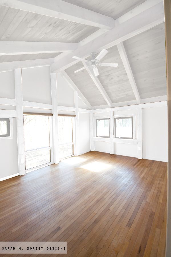 an empty room with wood floors and white walls