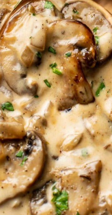 a wooden bowl filled with mushrooms covered in gravy