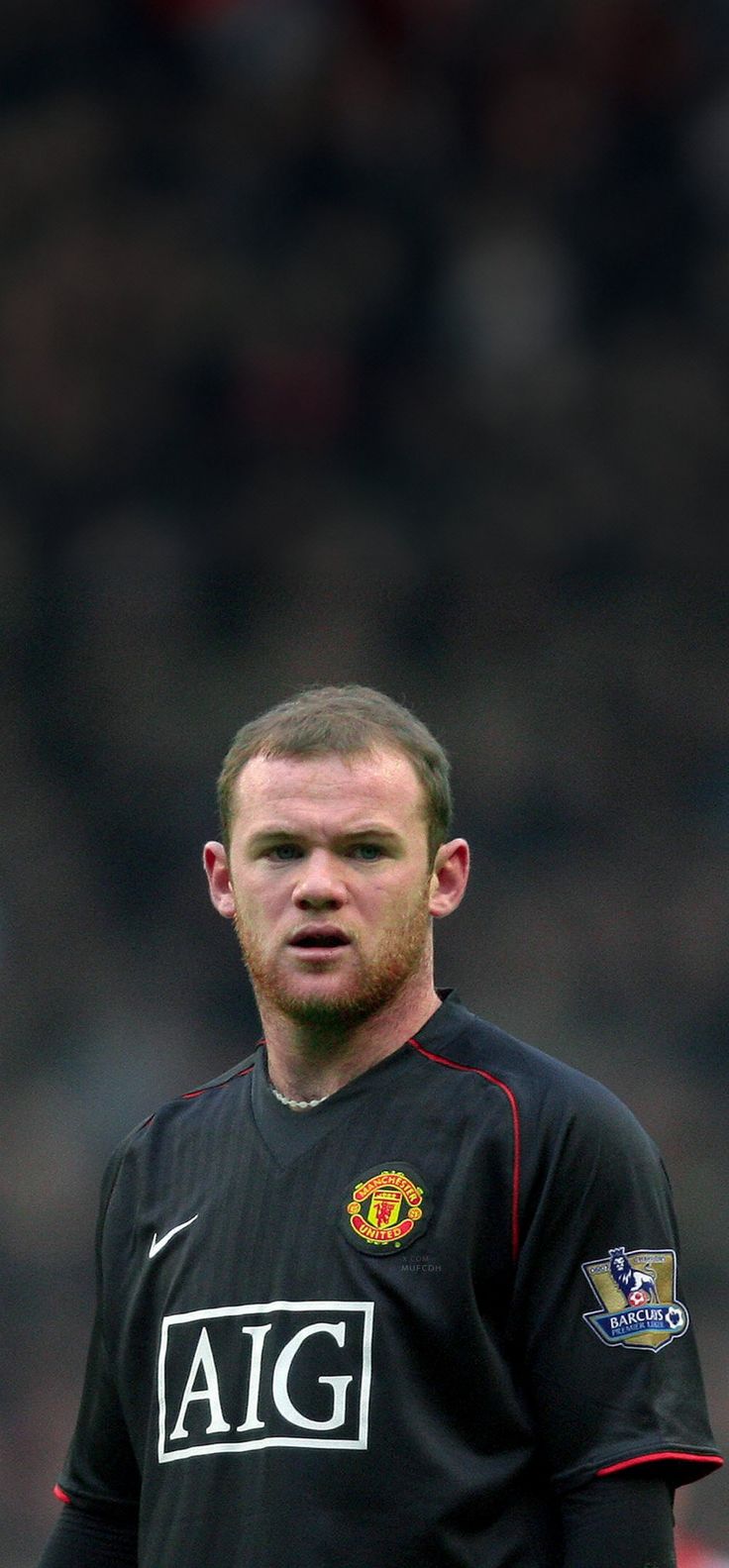 a man in black jersey standing on soccer field