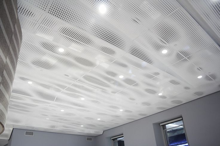 the ceiling is covered with white perforsants and lights in an empty room