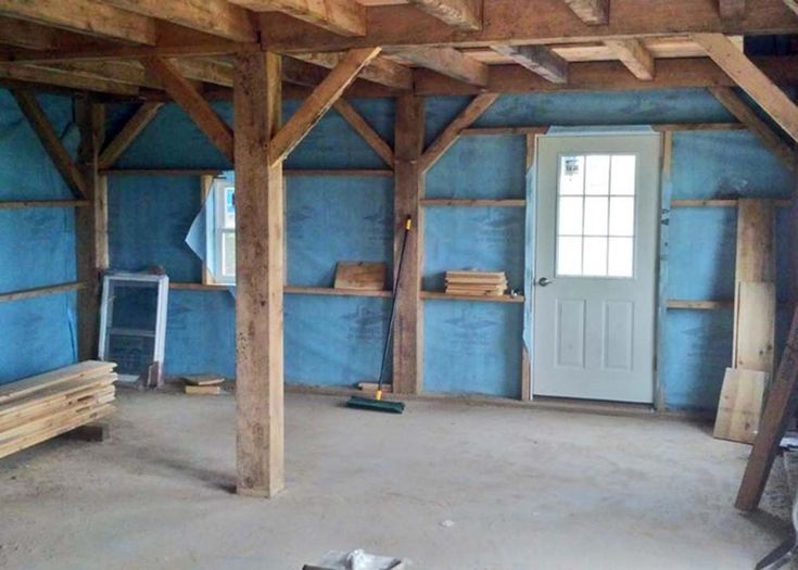 an unfinished room with blue walls and wooden beams