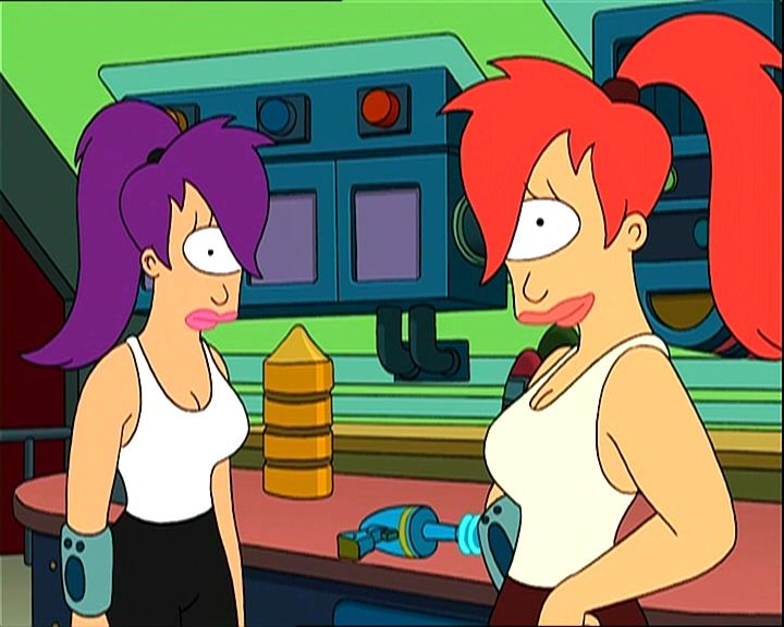 two women with red hair are standing in front of a machine and looking at each other