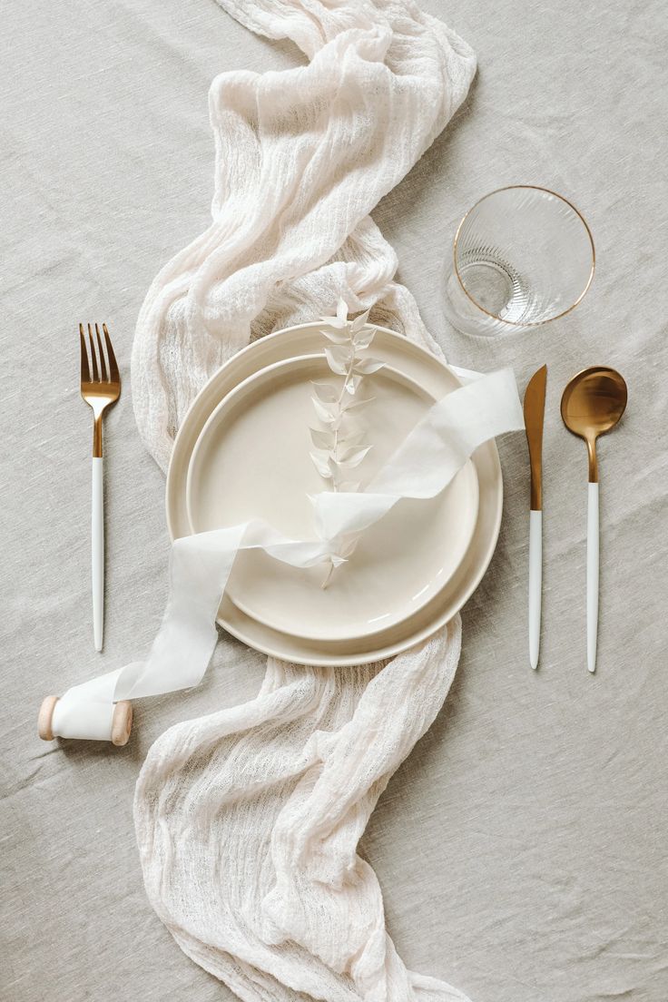 the table is set with silverware and napkins, along with a white cloth