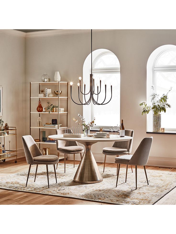 a dining room table with four chairs and a chandelier hanging from the ceiling