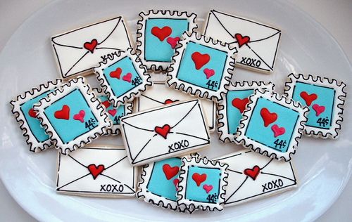 decorated cookies with envelopes and hearts are on a plate