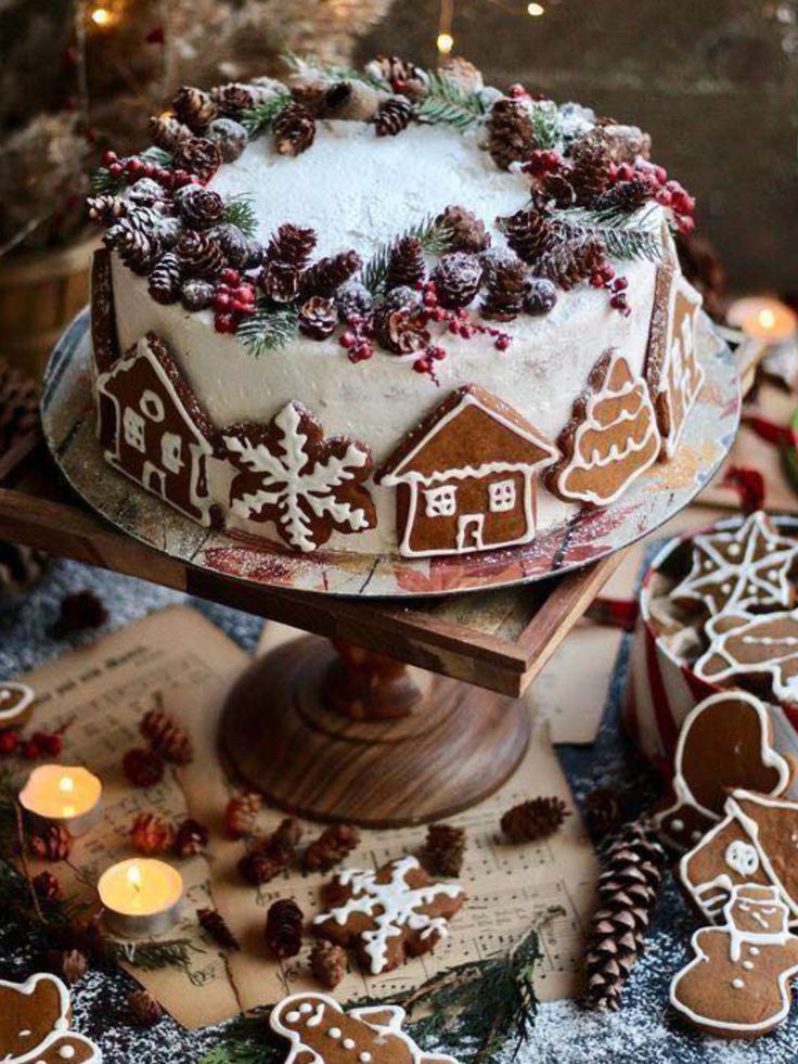 a decorated cake sitting on top of a table covered in cookies and frosted with icing