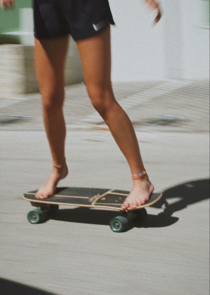 a woman riding a skateboard down a sidewalk