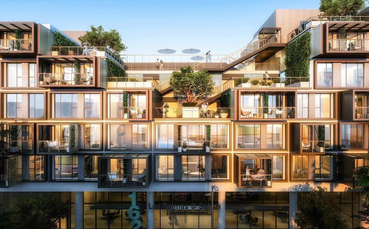 an apartment building with many balconies and plants on the top floor, surrounded by greenery