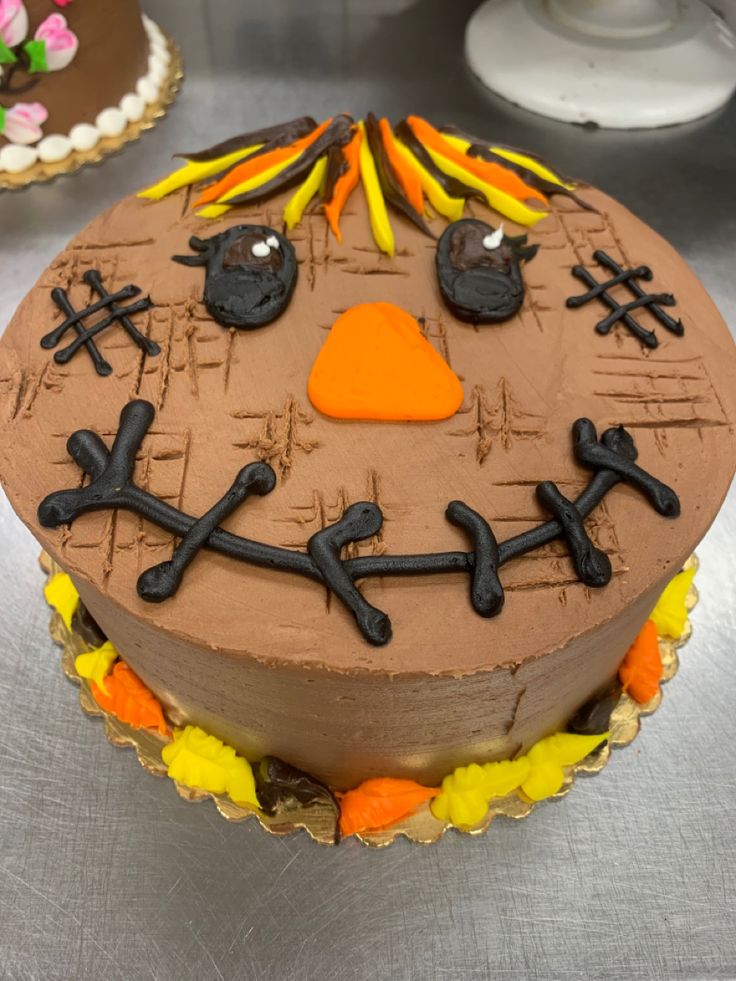 a chocolate cake decorated to look like a face with orange and black decorations on it