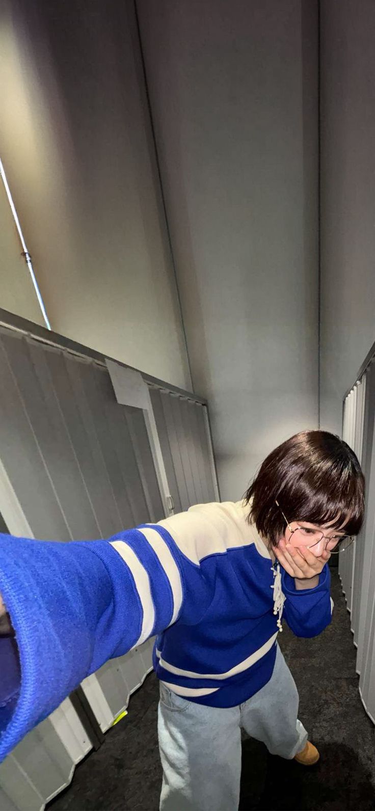 a young boy standing in front of a white refrigerator freezer next to a black floor