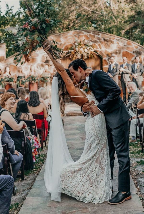 a bride and groom kissing in front of an outdoor ceremony