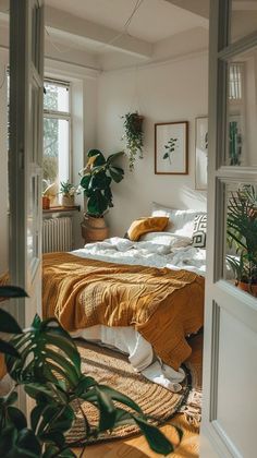 a bed sitting in a bedroom next to a window filled with potted greenery