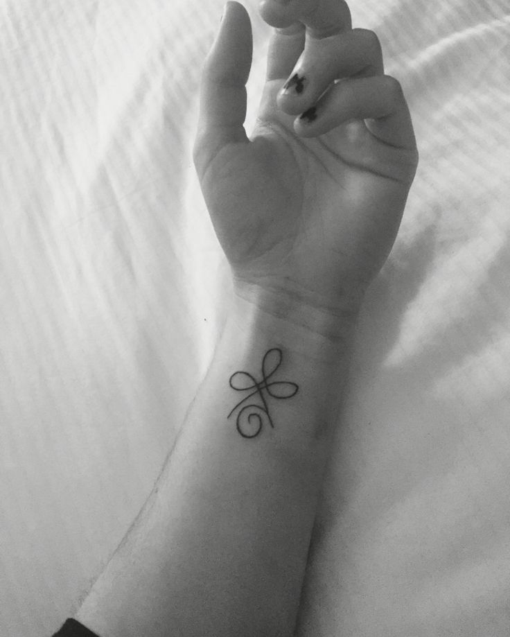 a person's hand with a small tattoo on it