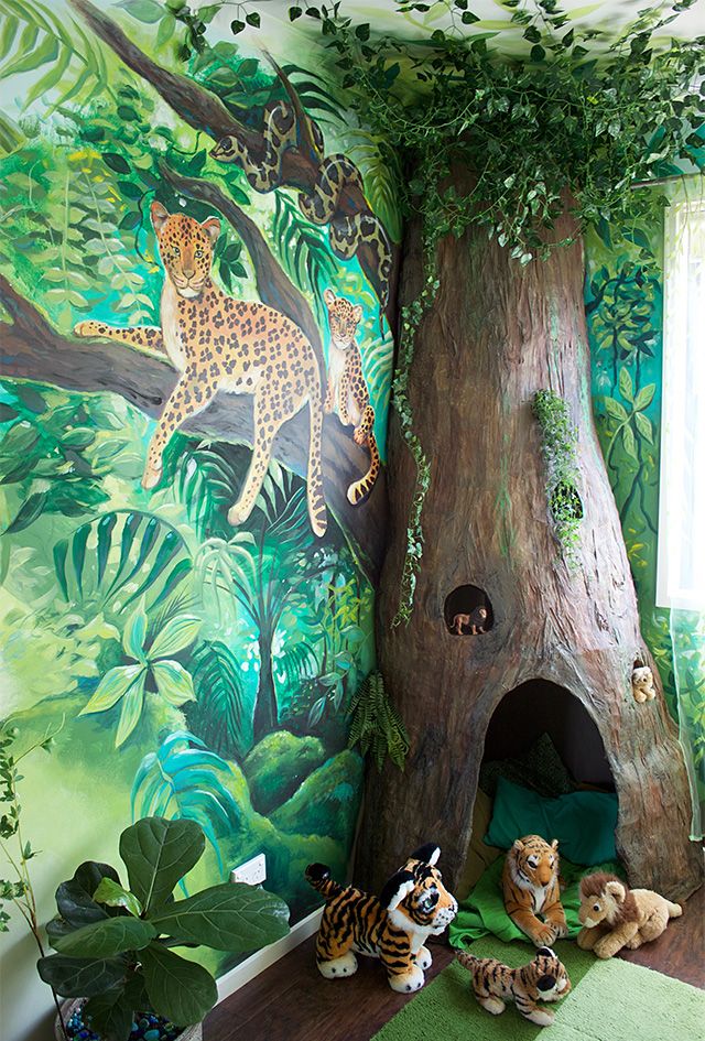 the children's room is decorated with jungle animals and a painted mural on the wall