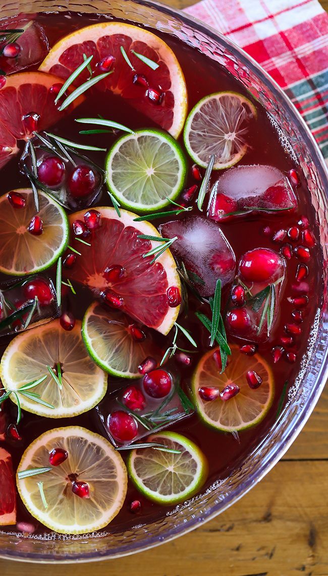 a bowl filled with fruit and garnish on top of a wooden table next to a plaid napkin