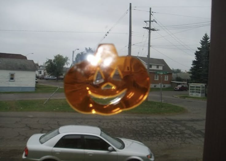 a car is parked in front of a window with an orange smiley face on it