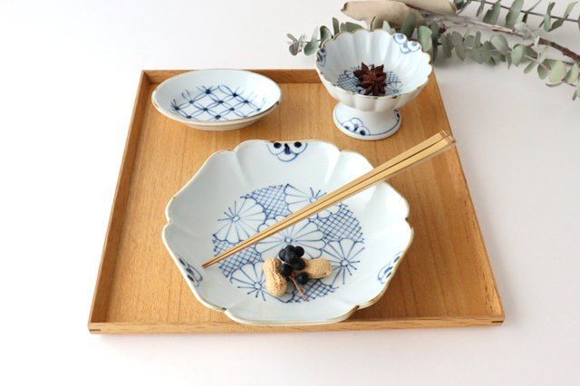 a wooden tray topped with bowls and chopsticks