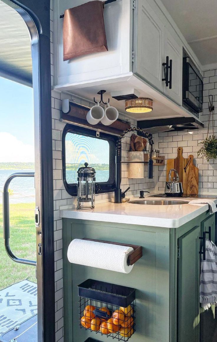 a kitchen area with a sink, stove and oven inside of a recreational travel trailer