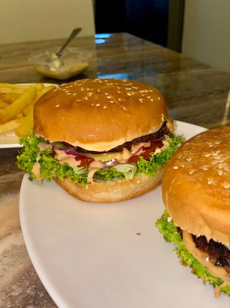 two hamburgers sitting on top of a white plate