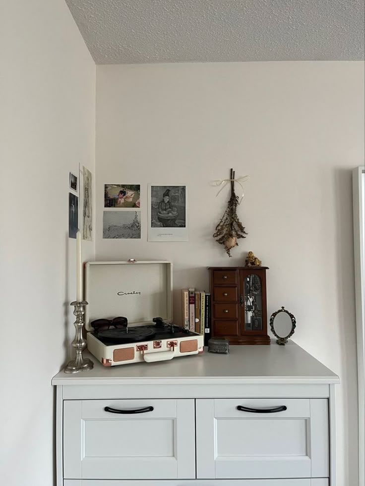 an old record player sits on top of a dresser in the corner of a room