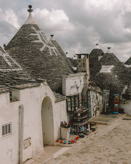 an old building with many roof tops and some buckets on the ground next to it