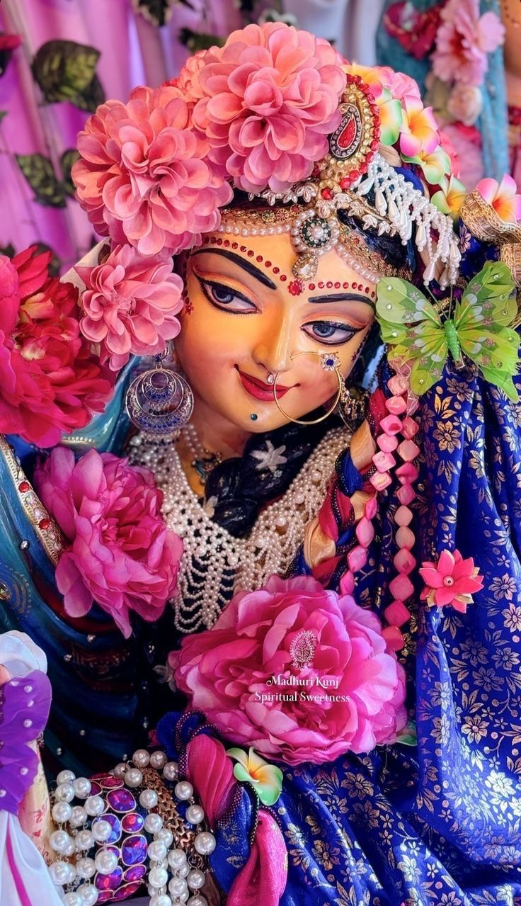 a colorful statue with flowers on it's head and face in front of other items