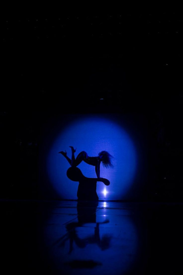 a woman is dancing in the dark on stage