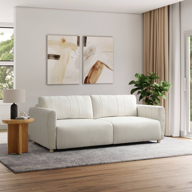 a white couch sitting on top of a hard wood floor next to a wooden table