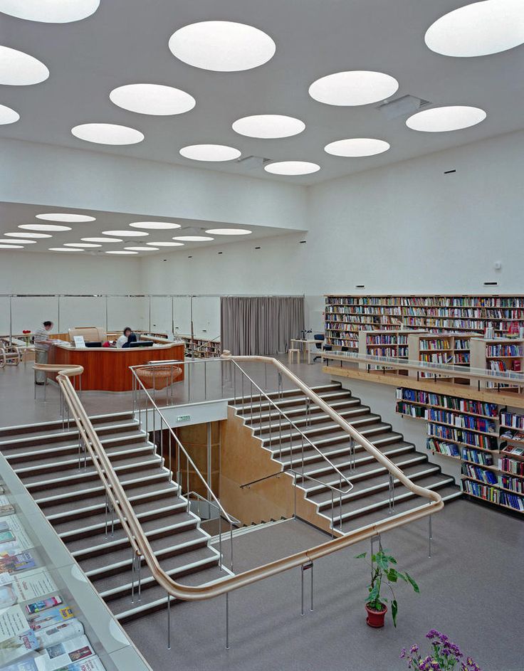 the interior of a library with many bookshelves and stairs leading up to them