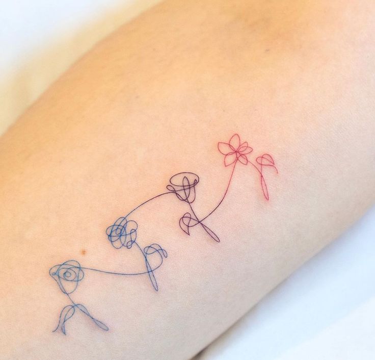 a small tattoo on the leg of a woman with flowers and balloons in it's hands