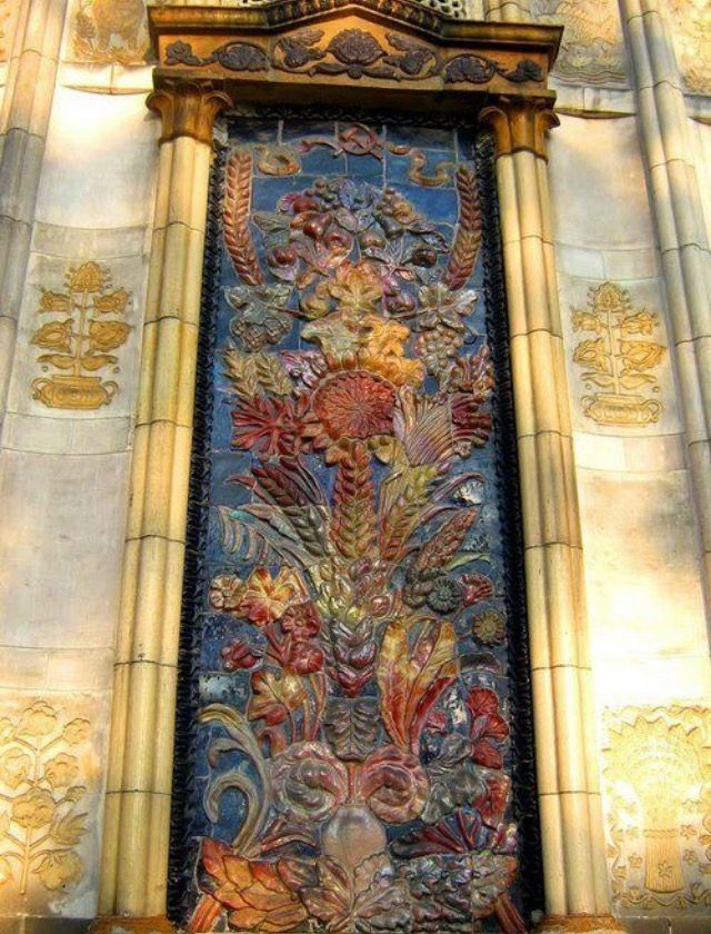 an ornate stained glass window on the side of a building