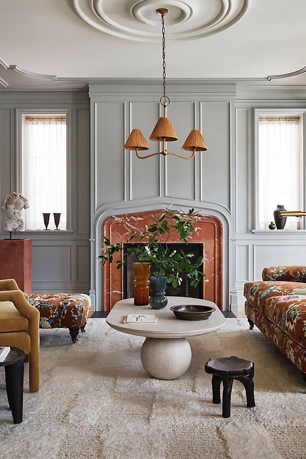 a living room filled with furniture and a fire place in the middle of a room