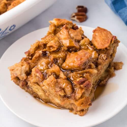 a white plate topped with dessert next to a bowl of pecan chips and a blue towel